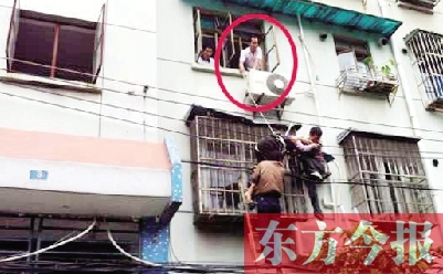 施救現(xiàn)場，劉鵬（圈內(nèi)）先用繩子捆住老太確保安全 勞動報記者 郭娜 供圖