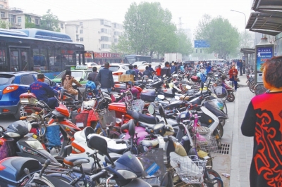 省人民醫(yī)院北門，路邊的公交站牌處停滿非機(jī)動(dòng)車，上、下客只能在快車道上。