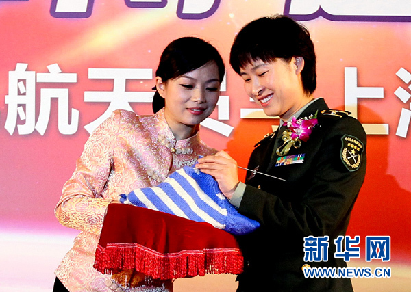 11月1日，航天員劉洋（右）在為“愛心”毛衣編織最后的收尾針。