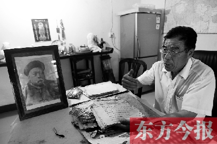 　魏樹紹手拿《物權(quán)法講義》手稿，在講訴先祖書寫“物權(quán)法”的歷史（相框里就是魏聯(lián)奎）