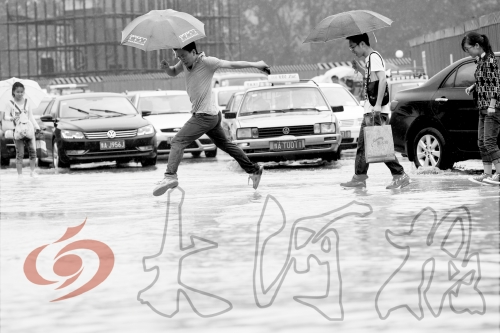 鄭州經(jīng)三路與北環(huán)交叉口處，積水較深，行人們不得不“練輕功”。 記者 白周峰 攝影