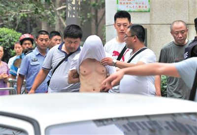 昨日，成都警方抓捕時與毒犯發(fā)生槍戰(zhàn)。一名男犯罪嫌疑人被警方押出。