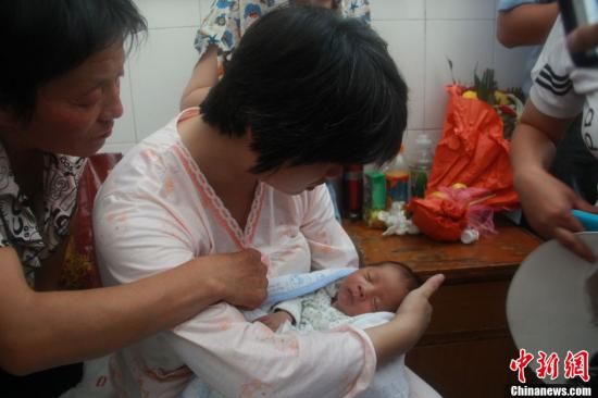 圖為陜西富平“產(chǎn)科醫(yī)生拐賣嬰兒”一案中的被拐嬰兒于8月5日中午在該縣婦幼保健院由當(dāng)?shù)鼐浇挥谄涓改?。張一?攝