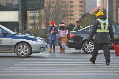 過(guò)斑馬線，行人左顧右盼，汽車(chē)寸土必爭(zhēng)。