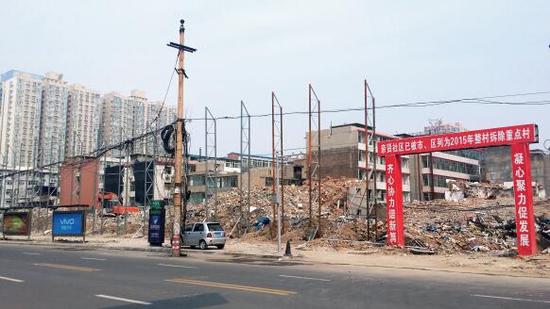 015年5月31日，在社區(qū)干部的帶頭拆遷下，親賢社區(qū)的“城中村改造”拉開帷幕。由于前期“清產(chǎn)核資”及補(bǔ)償標(biāo)準(zhǔn)等因素，拆遷改造工作推進(jìn)并不順利。圖為位于體育西路東側(cè)集體所有的商鋪率先被拆遷完畢，用于遮擋的圍擋正在施工中。（拍攝：2015年9月16日）