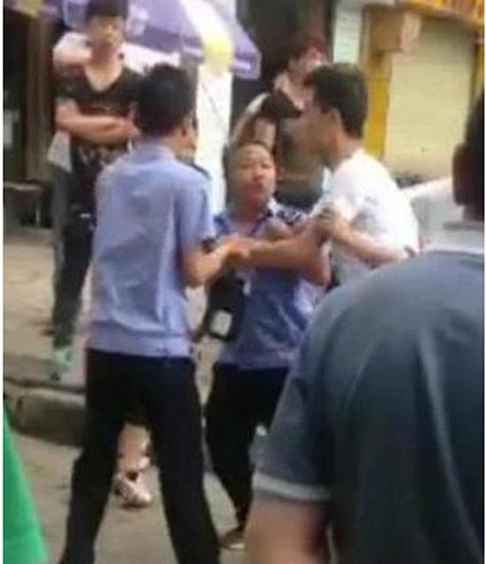 付某（右）與城管執(zhí)法人員廝打在一起。