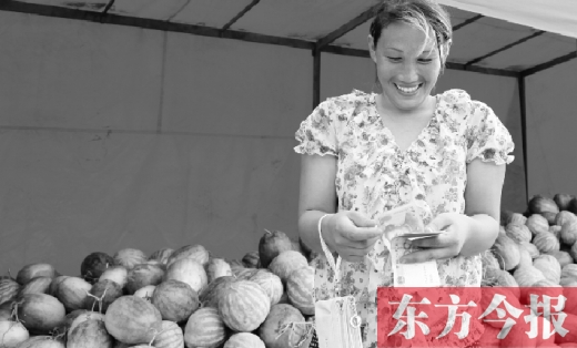 昨日，開封瓜農(nóng)史瑩瑩幸福地數(shù)著賣瓜錢 東方今報記者 沈翔 攝