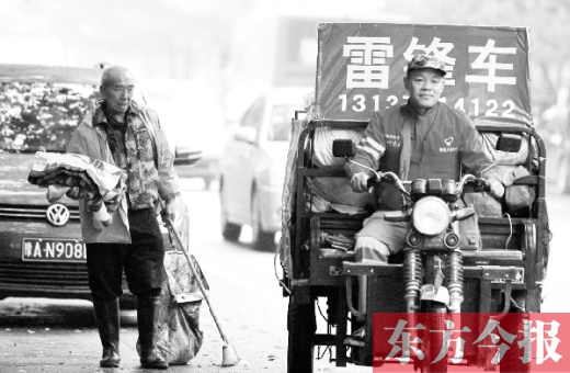 鄭州市商城路，一名環(huán)衛(wèi)工懷抱著剛剛收到的毯子，目送“雷鋒哥”孫德坤離開