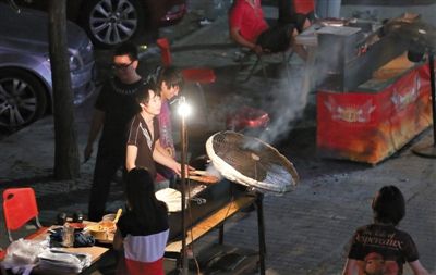 7月4日，青年路國(guó)美第一城小區(qū)附近的夜市臨街露天燒烤攤。