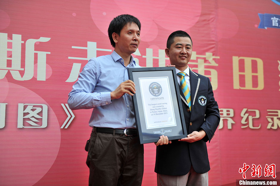 圖為世界吉尼斯認(rèn)證官為鄭春輝（左）頒發(fā)證書(shū)。呂明 攝