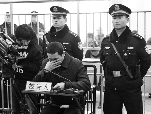 庭審中,29歲的李軍低著頭。