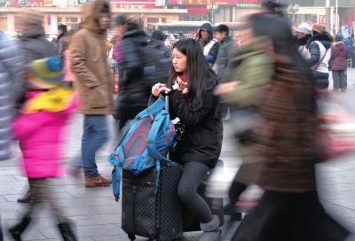 春運(yùn)首日，北京站客流量明顯增多，一名女孩在人流中等待進(jìn)站。