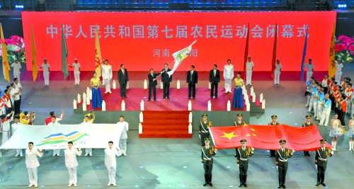 南陽市市長穆為民將農(nóng)運(yùn)會會旗遞交到下一屆東道主吉林省松原市市長李相國手里。