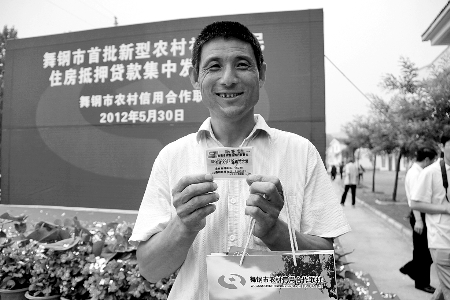 領(lǐng)到貸款，農(nóng)民開心地笑了。