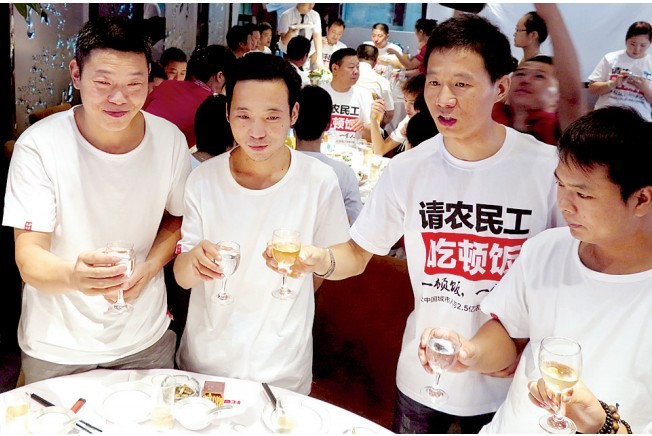 活動發(fā)起人張楠（右二）給農(nóng)民工敬酒。