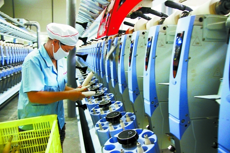 7月3日，在鄧州市永泰棉紡有限公司電腦控制全自動紡紗車間，紡織工人正在生產(chǎn)棉紗。