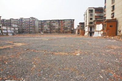 為降塵，旮旯王村拆遷后裸露的地面上鋪了一層石子。