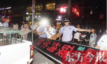 7月8日晚，鄭州市商城路一家占道經(jīng)營(yíng)的攤販招牌被執(zhí)法隊(duì)員“登記保存”