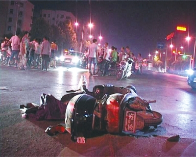 一輛白色無牌奧迪轎車在通過路口時(shí)，將一名騎電動(dòng)車的女子撞飛十多米