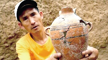 　　考古工作人員展示出土的仰韶文化時期代表性彩陶。