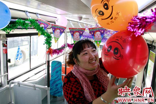 鄭州快速公交B3區(qū)間線車長李鵬云在車廂里懸掛氣球，布置圣誕車廂，營造歡樂圣誕氛圍