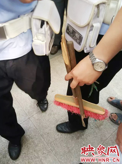 老太從環(huán)衛(wèi)工手中奪過掃帚，用腳踩斷，用力向環(huán)衛(wèi)工人的手上和腿上敲去。