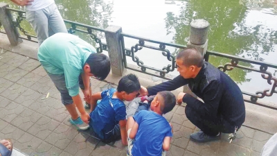 男孩被救出后，圍觀群眾幫他控水換衣服。