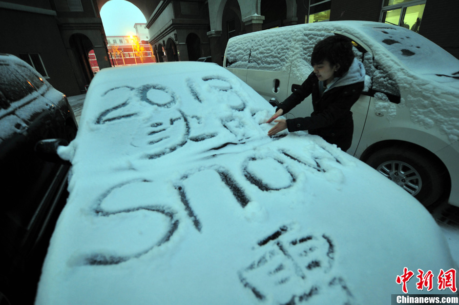 11月18日，行人在車輛的積雪上涂鴉。
