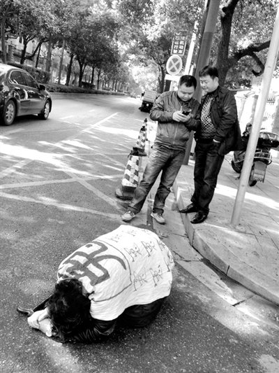 兩名接訪人員與患有癌癥的訪民段新德合影時(shí)，在拍照時(shí)查看手機(jī)。