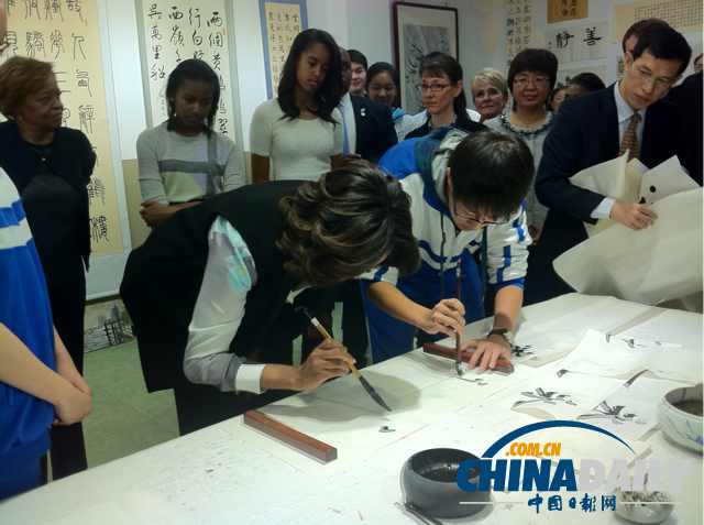 　北京時間3月21日，美國第一夫人米歇爾參觀北師大二附中時，與學(xué)生一起練習(xí)書法。