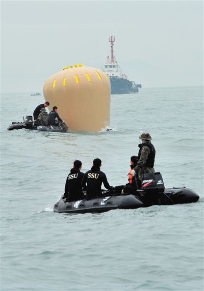 18日，搜救人員準備將氣囊捆綁到沉沒客輪上。