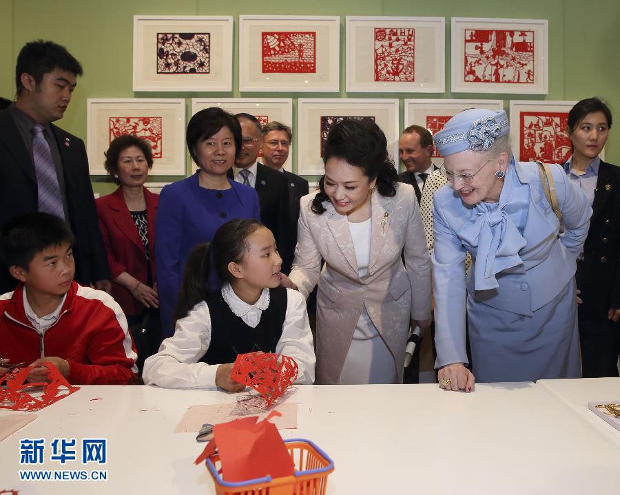 這是彭麗媛和瑪格麗特二世與根據(jù)安徒生童話中人物和情節(jié)制作剪紙的孩子交談。