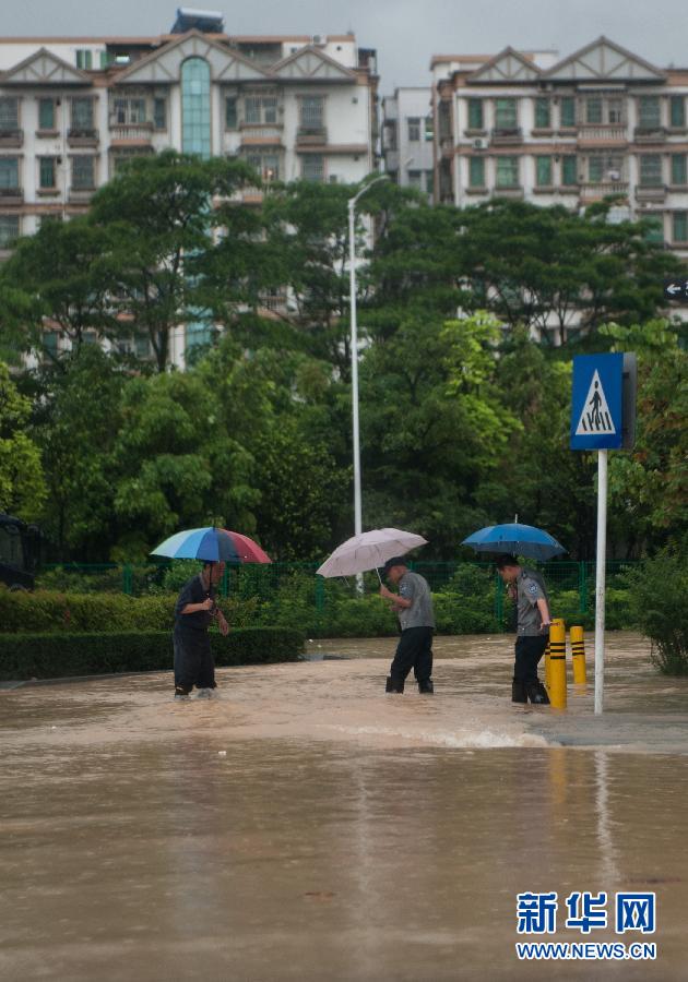 5月11日，人們在深圳西麗涉水行走。