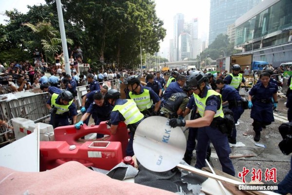10月14日，警方清除金鐘道障礙物。大批警員在金鐘道現(xiàn)場清拆障礙物。部分警員戴上頭盔將障礙物移走。