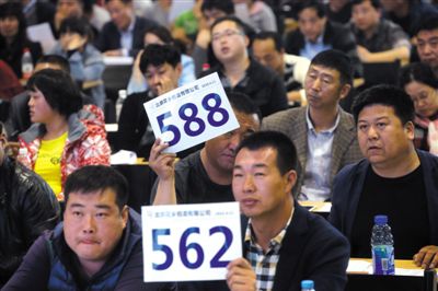昨日，拍賣現(xiàn)場競拍者舉牌競拍。新京報記者
