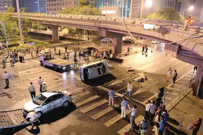路虎沖下國(guó)貿(mào)橋砸中一輛起亞轎車(chē)，橋上厚達(dá)幾十厘米的水泥護(hù)欄被撞斷，碎石四處散落，數(shù)十群眾在現(xiàn)場(chǎng)圍觀。