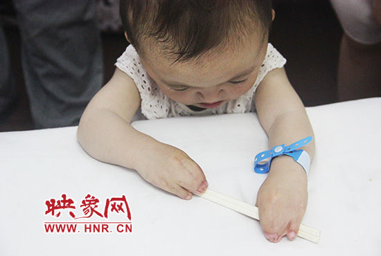 孩子握著筷子發(fā)呆。
