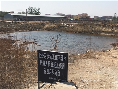化肥廠滲坑的三分之一經(jīng)過治理，但水質(zhì)仍然呈黃褐色。