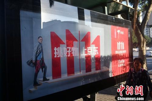 資料圖：11月1日，福州民眾從雙十一廣告牌前經(jīng)過。中新社記者 呂明 攝