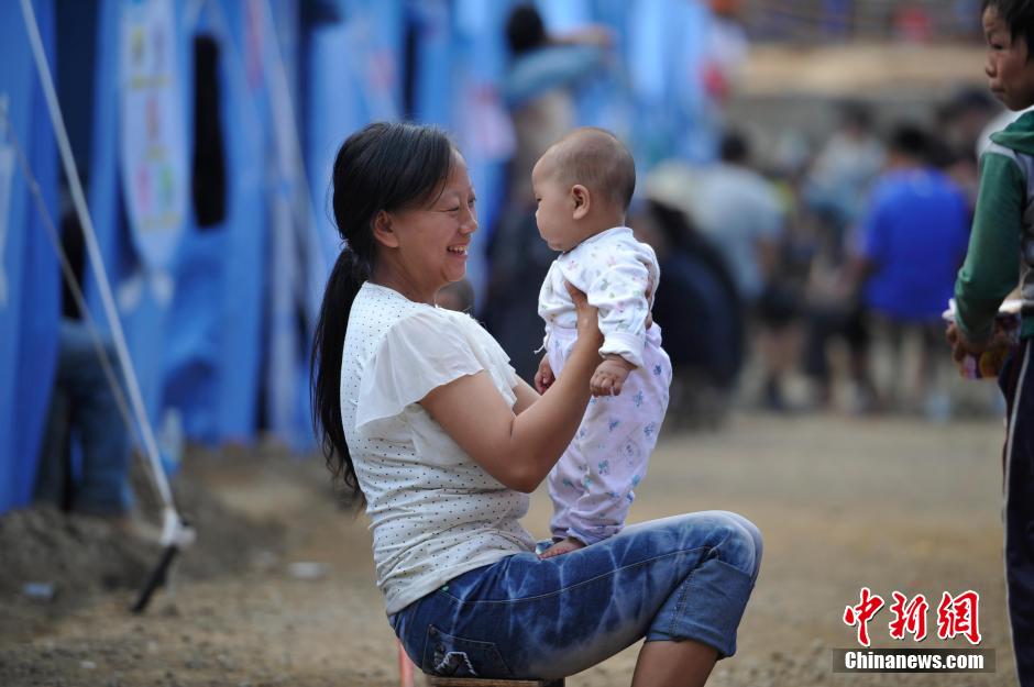 8月6日，一名年輕的母親在和孩子玩樂。
