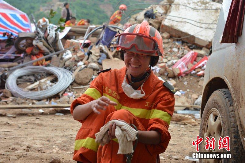 2014年8月5日，女兵在云南魯?shù)辇堫^山鎮(zhèn)廢墟中搜救被困者。