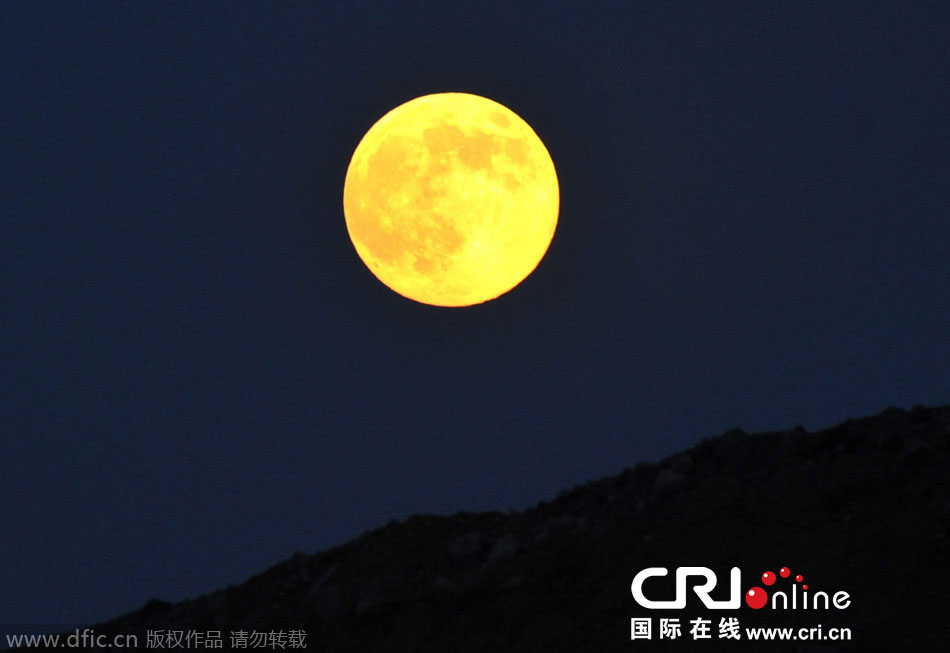 8月10日晚，一輪金燦燦的大月亮在遼寧省大連市東方升起。圖片來源：劉德斌/東方IC