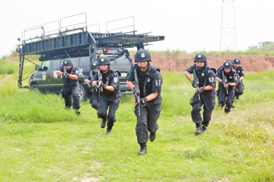 在拍攝現(xiàn)場，特警隊(duì)員下車后快速出擊。記者張琮攝影