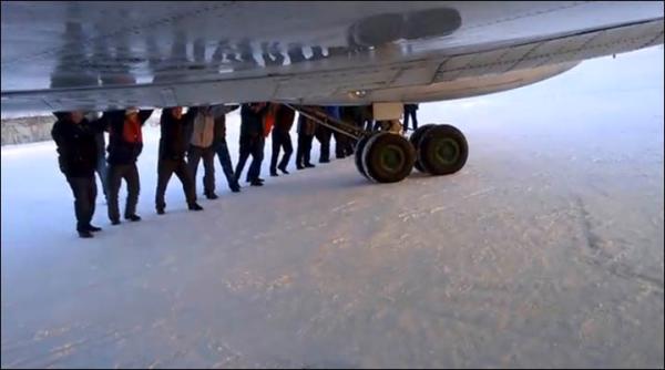 　伊加爾市一架客機起飛前被凍在了跑道上。飛機上的乘客不得不下來推飛機。