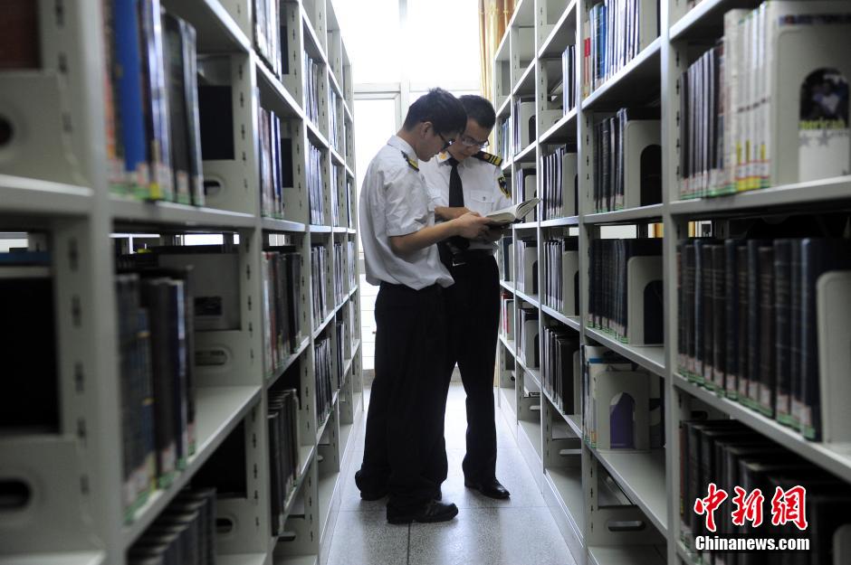 5月8日，武漢輕工大學保安吳濤與江力在圖書館交流學習。中新社發(fā) 張暢 攝