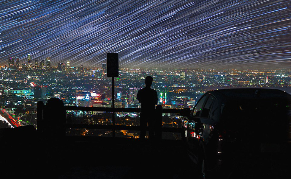 照片中，一名男子看著流星和隕星劃過天空。（網(wǎng)頁截圖）