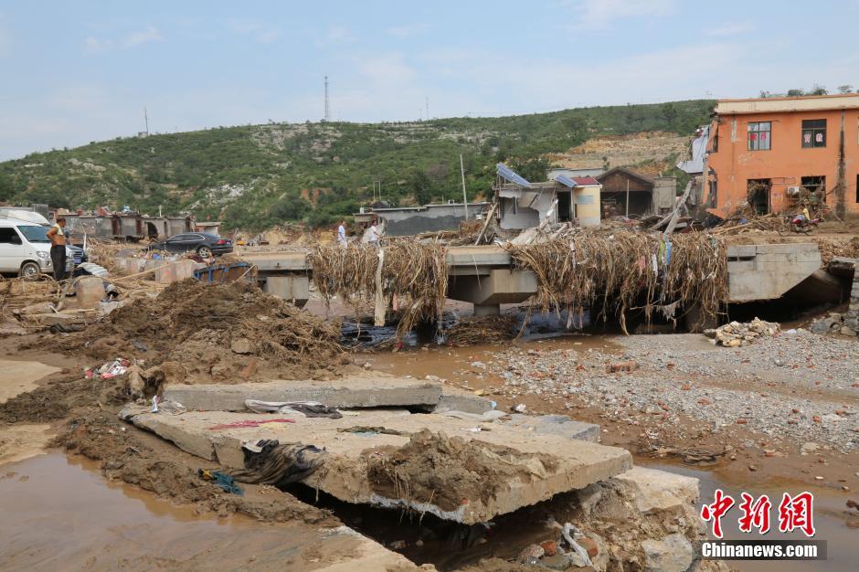 圖為洪水過后，坍塌的橋梁上遺落大量雜草。