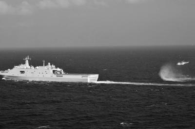 11日，抵達(dá)馬航飛機(jī)失聯(lián)海區(qū)的海軍井岡山艦與艦載直升機(jī)協(xié)同展開立體搜救行動。新華社發(fā)