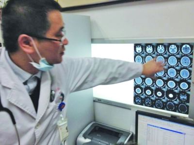 醫(yī)生在查看男孩的腦部CT片。薛馬義 攝