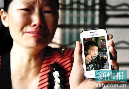 男童的舅媽拿著小益的照片,悲痛欲絕。 新快報記者 畢志毅 攝